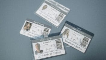 High-angle view of medical ID badges for chief surgeons on a gray surface.