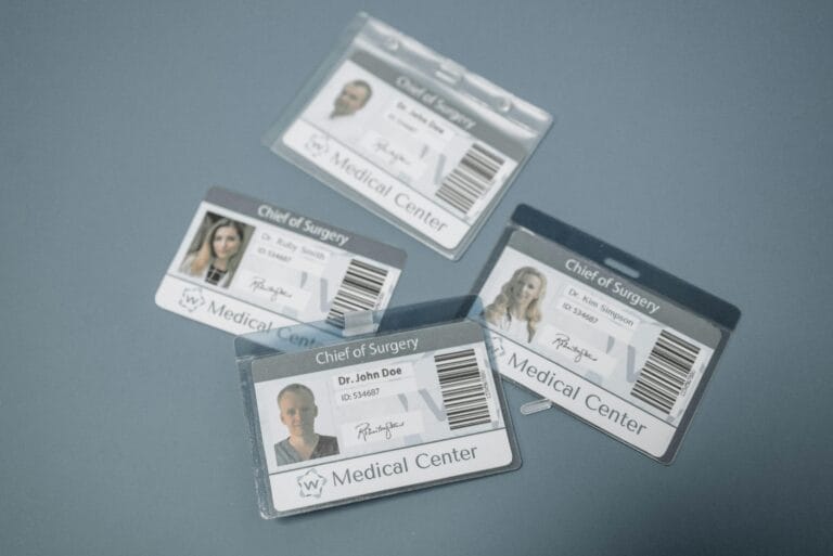 High-angle view of medical ID badges for chief surgeons on a gray surface.